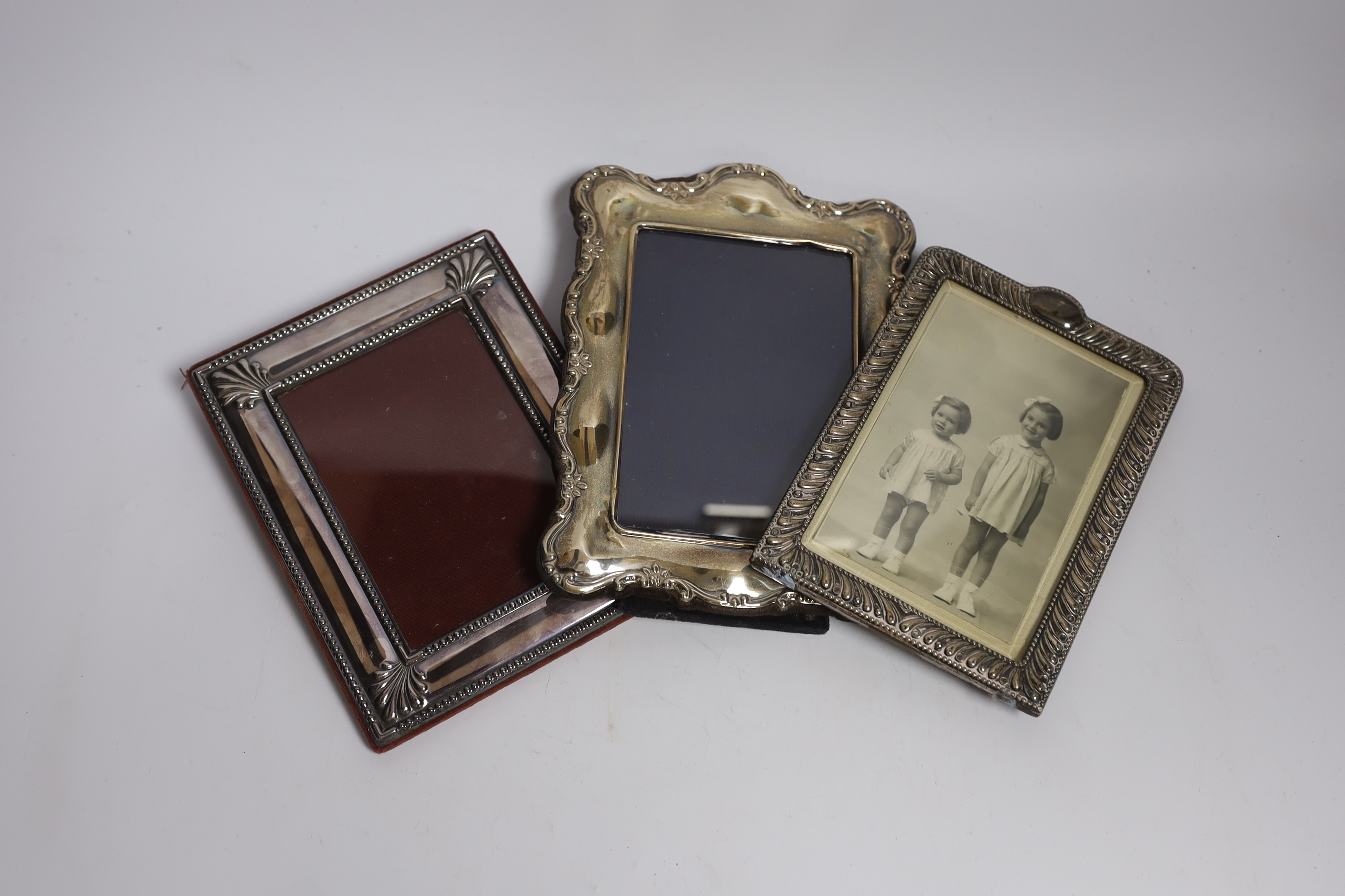 A late Victorian repousse silver mounted photograph frame, Birmingham, 1898, 17.3cm, together with a modern silver mounted photograph frame and silver plated frame.